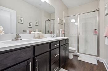 A bathroom with a white sink and a glass shower stall.